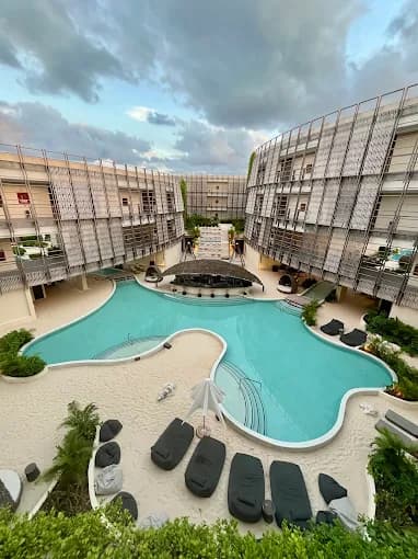 Aerial view of Artia Condos central courtyard pool with white sand deck in Aldea Zama
